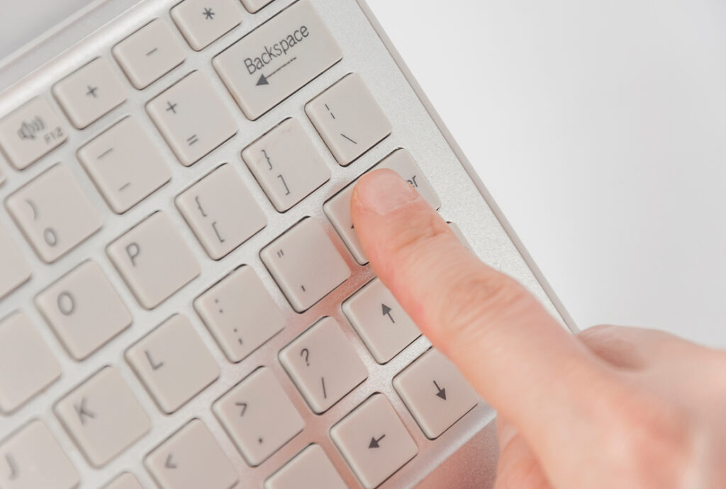 Persona presionando la tecla "enter" de un teclado